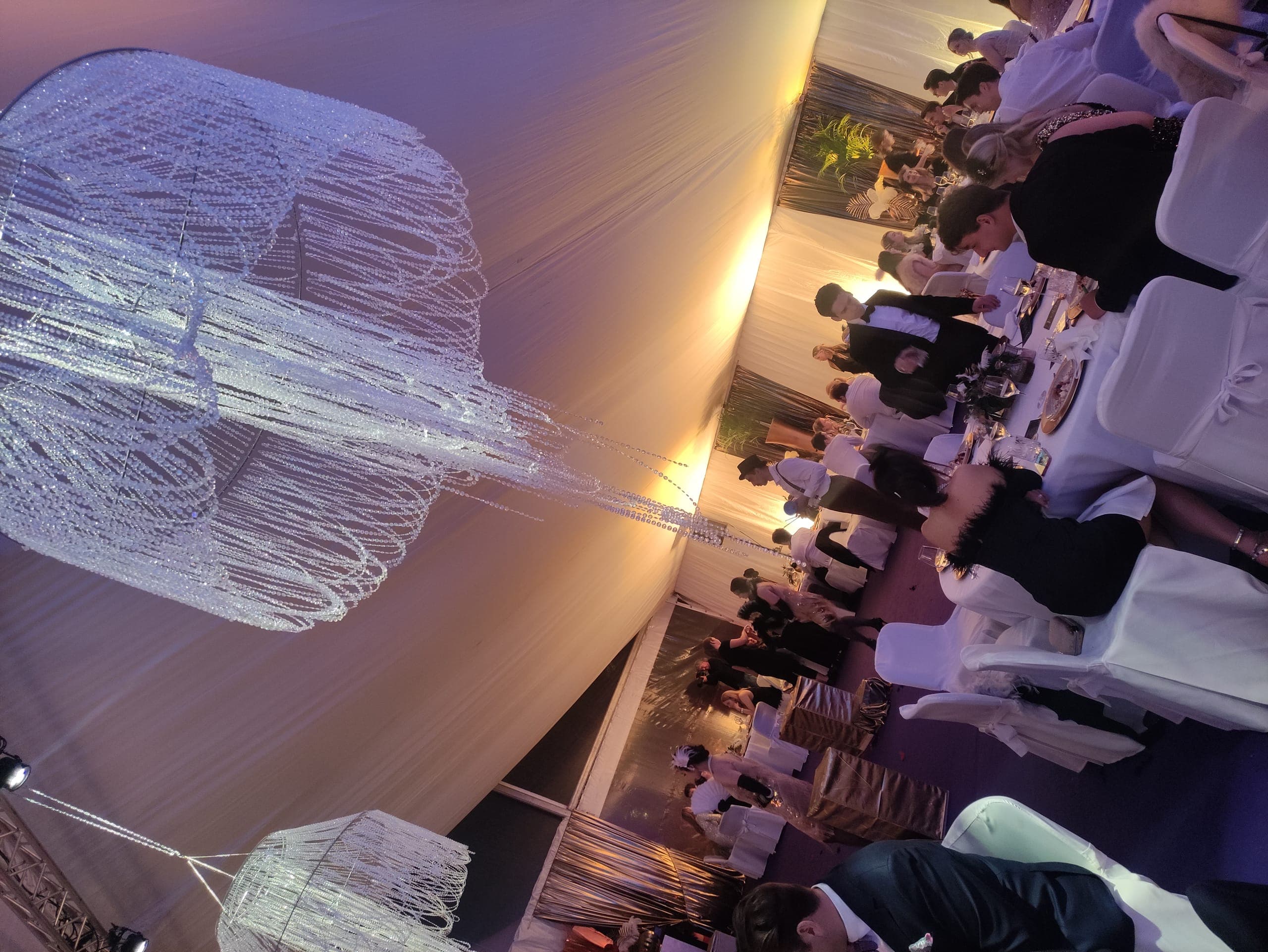 Gäste bei einer Motto-Gala im festlich dekorierten Zelt